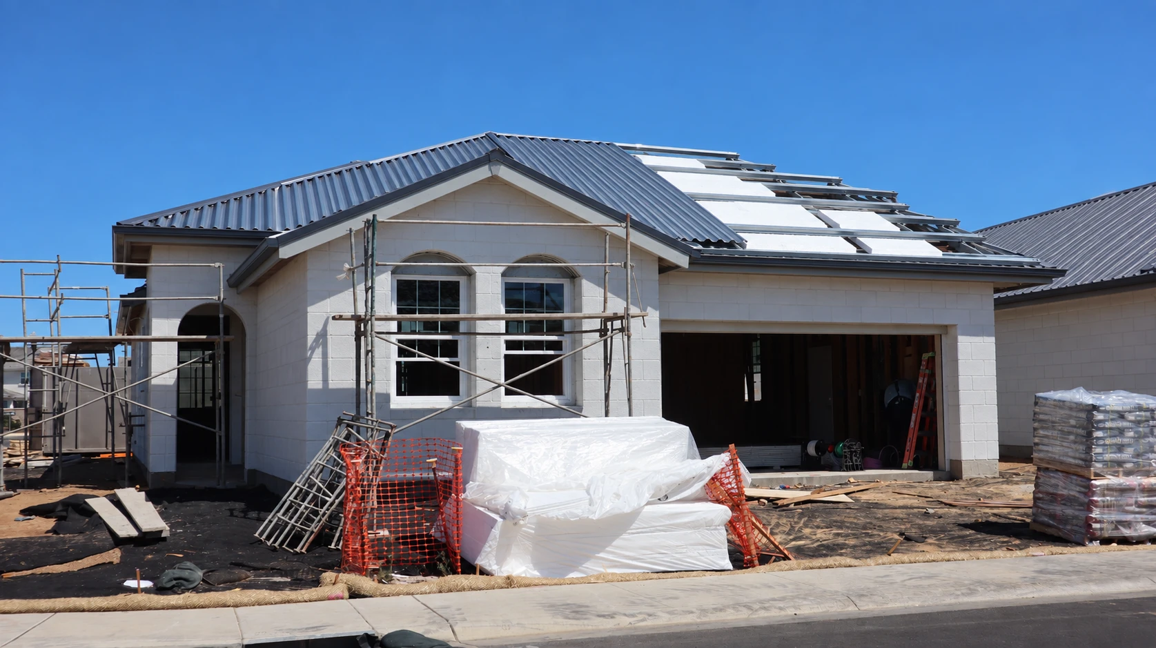 Casa de una planta en construcción con láminas EPS Durapor colocadas bajo el techo de lámina metálica